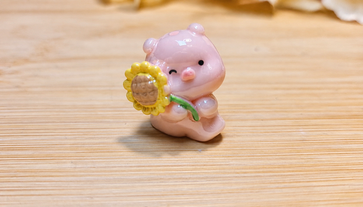 Cerdito sujetando una flor