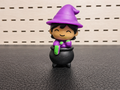 Figura decorativa de brujita morada con caldero negro