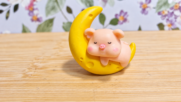 Figura cerdito dormido sobre la luna