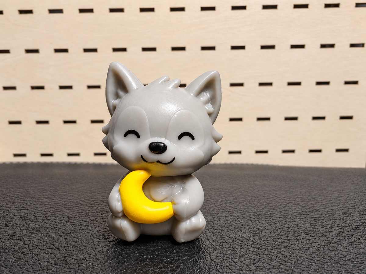 Figura decorativa de gatito gris sosteniendo una luna amarilla