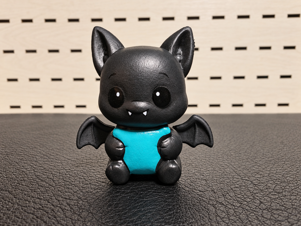 Figura decorativa de murciélago negro con vientre turquesa
