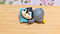 Figura pingüino durmiendo sobre una almohada azul
