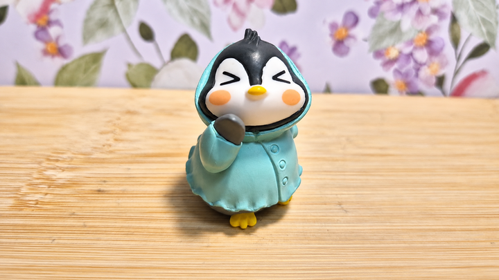 Figura pingüino con impermeable turquesa