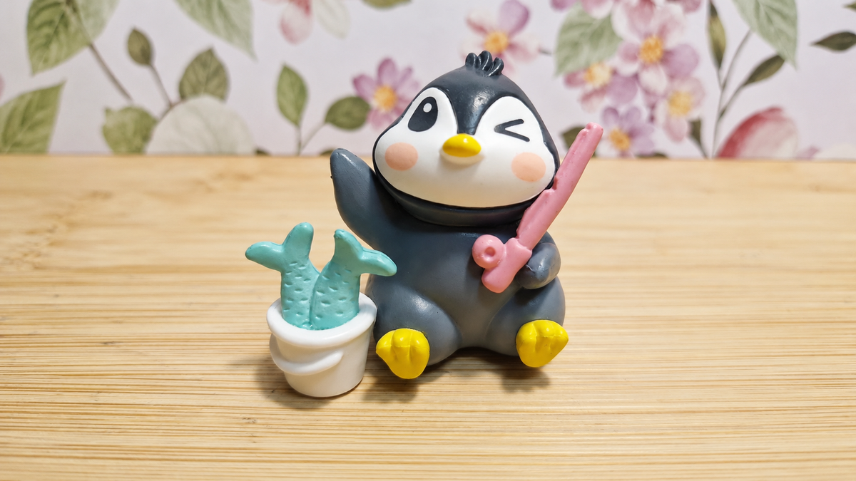 Figura de pingüino peluquero con tijeras rosas